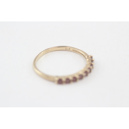 113 - 9ct gold garnet half eternity ring, claw set (1.3g) AS SEEN - MISHAPEN Size  P