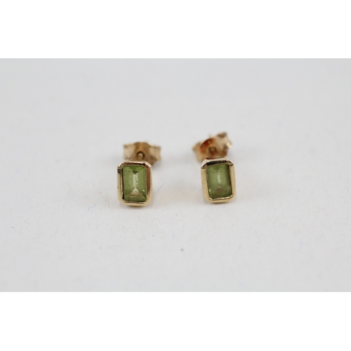 156 - 9ct gold baguette cut peridot stud earrings with scroll backs (1.1g)