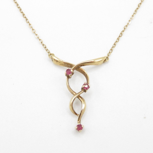 225 - 9ct gold ruby set ribbon twist set static pendant necklace (2.1g)