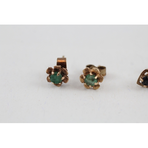 61 - 2x 9ct gold sapphire & emerald stud earrings with scroll backs (1.7g)