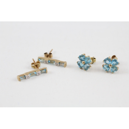 81 - 2x 9ct gold blue topaz & diamond earrings with scroll backs (2.9g)