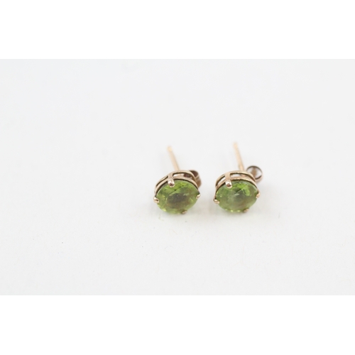 47 - 9ct gold peridot stud earrings with scroll backs (0.7g)