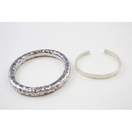 341 - Two silver hammered modernist bangles (73g)