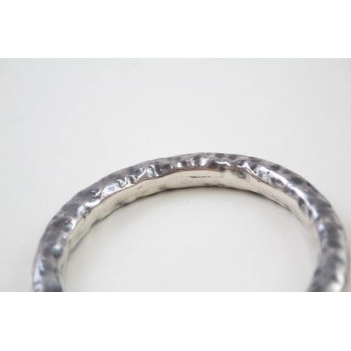 341 - Two silver hammered modernist bangles (73g)