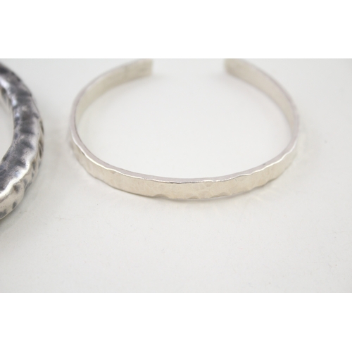 341 - Two silver hammered modernist bangles (73g)