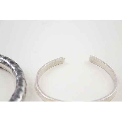 341 - Two silver hammered modernist bangles (73g)