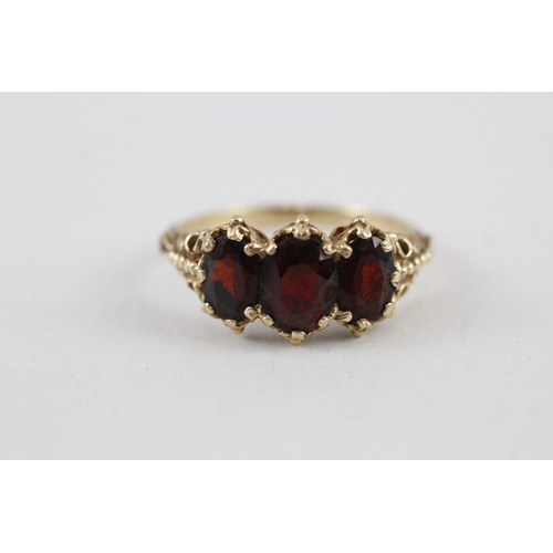 104 - 9ct gold vintage garnet trilogy dress ring with patterned gallery (4.1g) Size  T