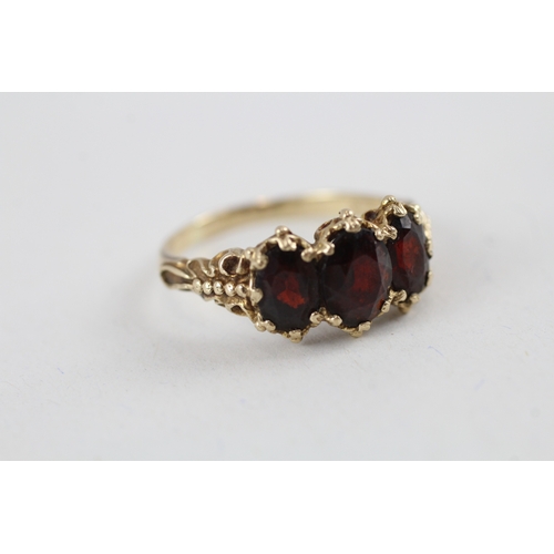 104 - 9ct gold vintage garnet trilogy dress ring with patterned gallery (4.1g) Size  T