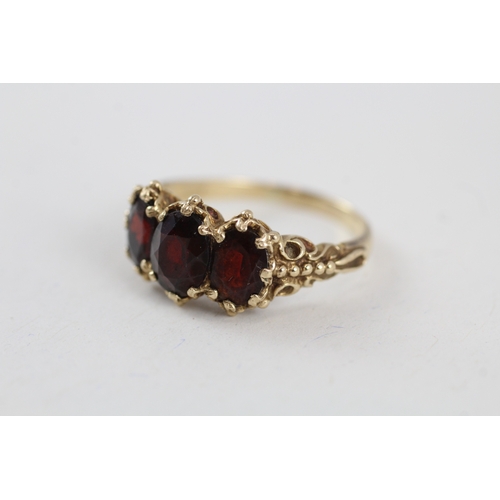 104 - 9ct gold vintage garnet trilogy dress ring with patterned gallery (4.1g) Size  T