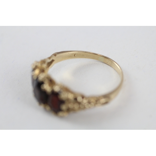 104 - 9ct gold vintage garnet trilogy dress ring with patterned gallery (4.1g) Size  T