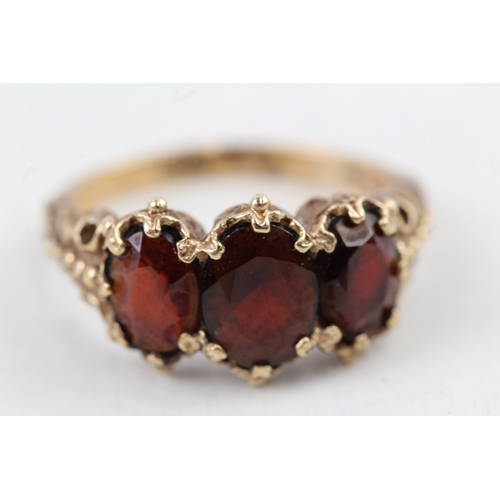 112 - 9ct gold vintage garnet three stone ring with patterned shoulders (3.6g) Size  K 1/2