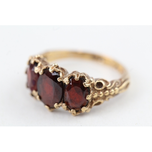 112 - 9ct gold vintage garnet three stone ring with patterned shoulders (3.6g) Size  K 1/2