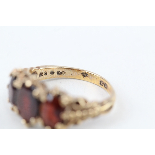 112 - 9ct gold vintage garnet three stone ring with patterned shoulders (3.6g) Size  K 1/2