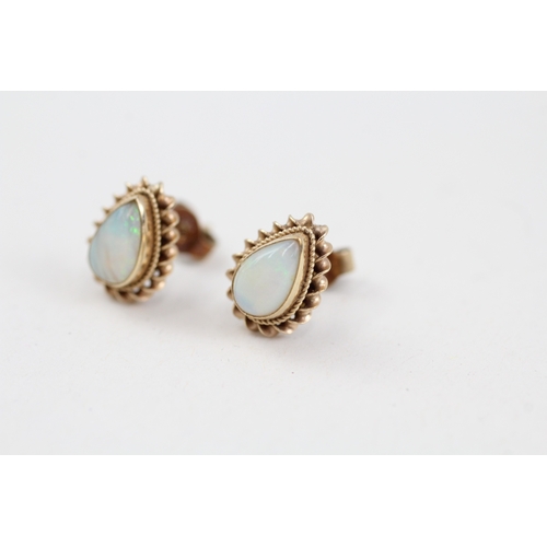 147 - 9ct gold pear cut opal stud earrings with scroll backs (1.4g)