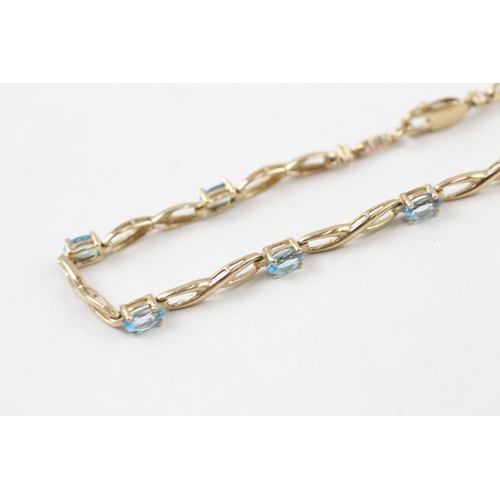 253 - 9ct gold oval cut blue topaz bracelet (4.4g)