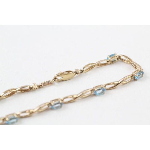 253 - 9ct gold oval cut blue topaz bracelet (4.4g)