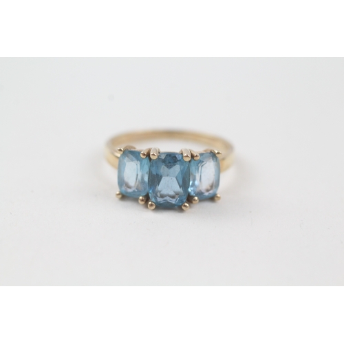 57 - 9ct gold blue topaz trilogy dress ring (2.9g) Size  P 1/2