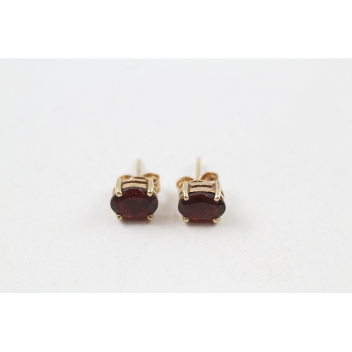 12 - 9ct gold oval cut garnet stud earrings (1.4g)