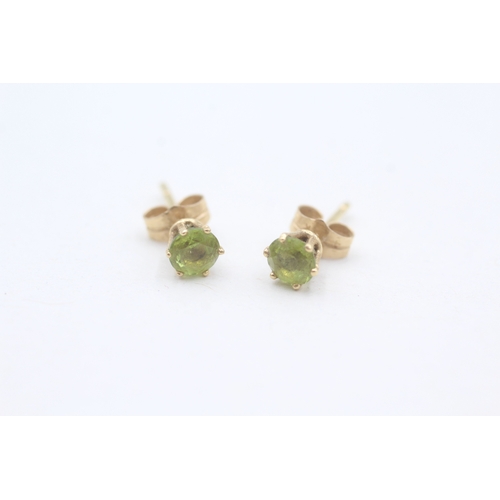 115 - 18ct gold claw set round cut peridot stud earrings (1.2g)