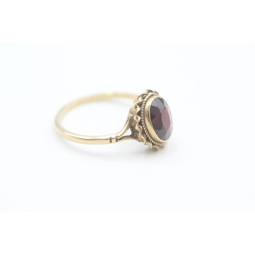 174 - 9ct gold rope edged oval cut garnet dress ring (2.2g) Size  Q