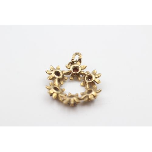 219 - 9ct gold garnet floral openwork pendant (1.9g)