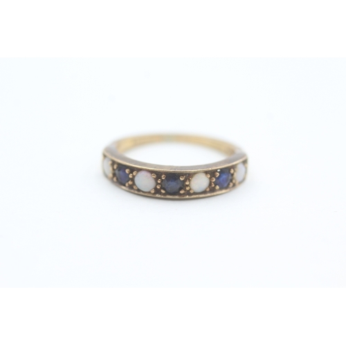 81 - 9ct gold opal and sapphire set seven stone eternity ring (2g) Size  K