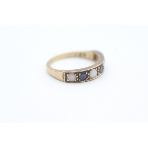 81 - 9ct gold opal and sapphire set seven stone eternity ring (2g) Size  K