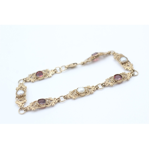 76 - 9ct gold garnet and cultured pearl set scrolling station bracelet (5.6g)