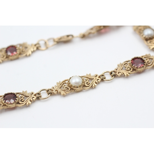 76 - 9ct gold garnet and cultured pearl set scrolling station bracelet (5.6g)