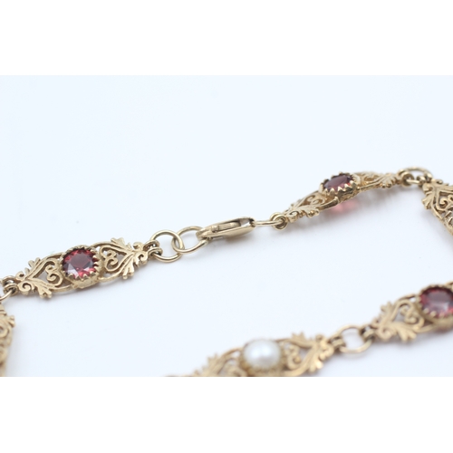 76 - 9ct gold garnet and cultured pearl set scrolling station bracelet (5.6g)