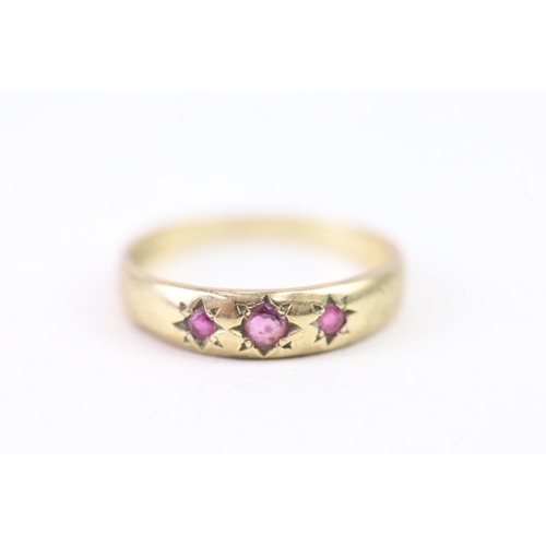 133 - 9ct gold star set ruby trilogy band ring (1.6g) Size  M 1/2