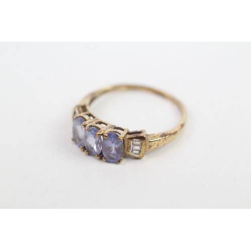 143 - 9ct gold baguette cut diamond accented oval tanzanite trilogy ring (1.9g) Size  O 1/2