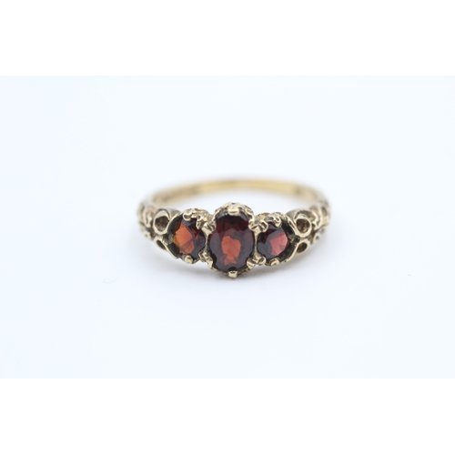 164 - 9ct gold garnet set trilogy ring (2.7g) Size  M 1/2