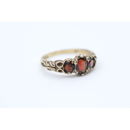 164 - 9ct gold garnet set trilogy ring (2.7g) Size  M 1/2