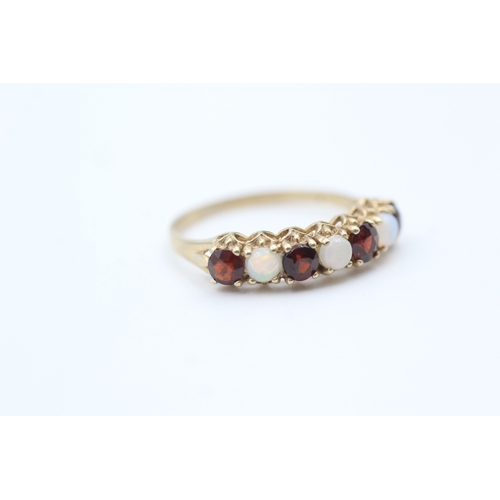 177 - 9ct gold opal and garnet set seven stone eternity ring (1.7g) Size  O