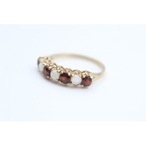 177 - 9ct gold opal and garnet set seven stone eternity ring (1.7g) Size  O