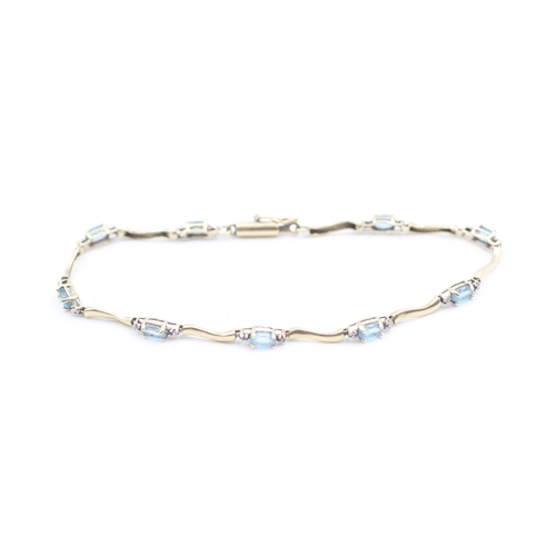 9 - 10kt gold blue topaz set station bracelet (3.8g)