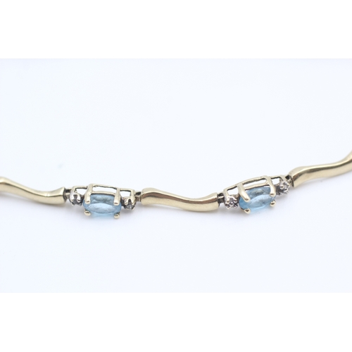 9 - 10kt gold blue topaz set station bracelet (3.8g)