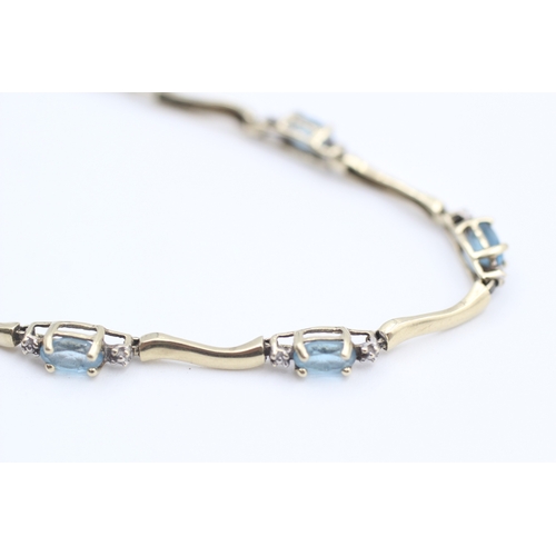 9 - 10kt gold blue topaz set station bracelet (3.8g)