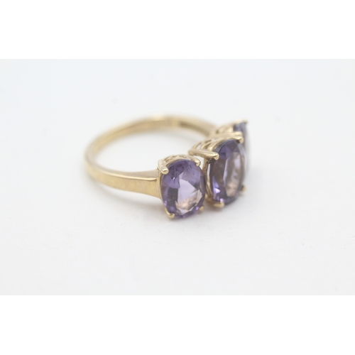 91 - 9ct gold oval cut amethyst three stone ring (2.6g) Size L