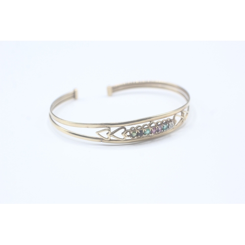 5 - 9ct gold 'DEAREST' torc bangle, gemstones including: diamond, emerald, amethyst ruby, sapphire & tou... 