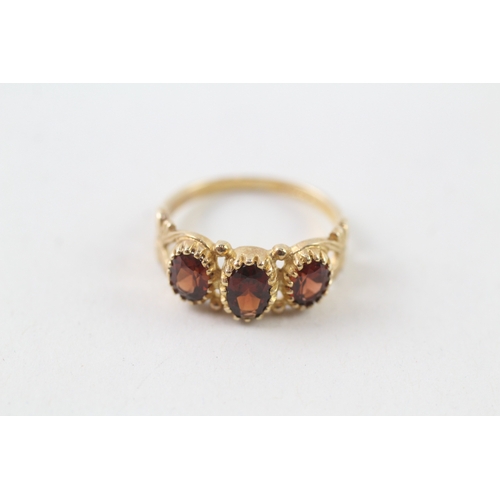 102 - 9ct gold garnet set trilogy ring (2.3g) Size L 1/2