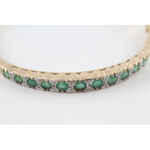 97 - 9ct gold diamond and emerald set bangle (11.6g)