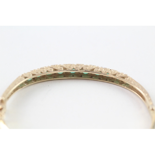 97 - 9ct gold diamond and emerald set bangle (11.6g)