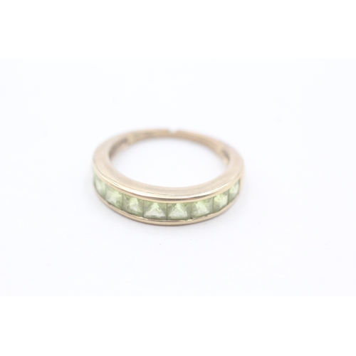 64 - 9ct gold and peridot channel set ring (2.2g) AS SEEN - MISSHAPEN Size L 1/2