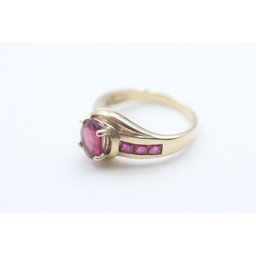 91 - 9ct gold tourmaline centre stone and ruby side set ring (3.9g) Size N