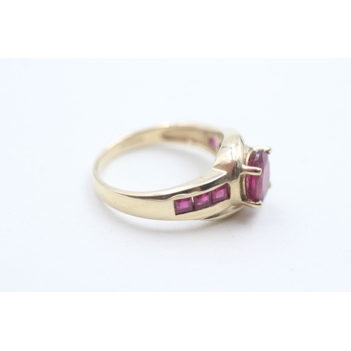 91 - 9ct gold tourmaline centre stone and ruby side set ring (3.9g) Size N