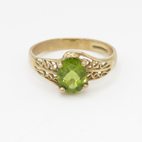 115 - 9ct gold peridot dress ring with patterned shoulders (2g) Size O 1/2