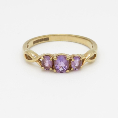 165 - 9ct gold amethyst three stone ring (1.9g) Size P