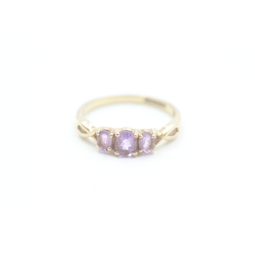 165 - 9ct gold amethyst three stone ring (1.9g) Size P